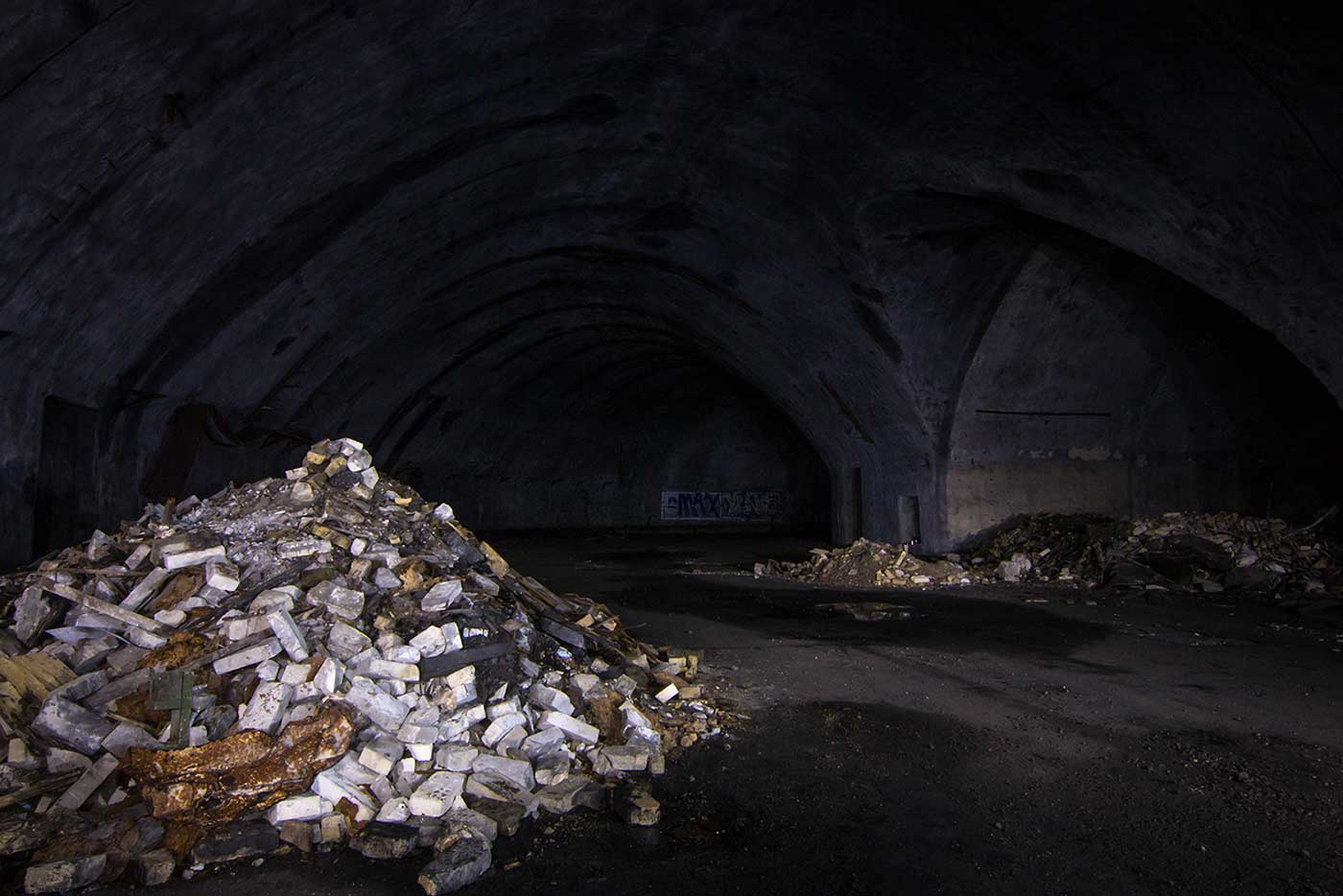 Today the underground aircraft galleries of the Željava Airbase are bare and abandoned, forming a pitch-black labyrinth beneath the mountain.