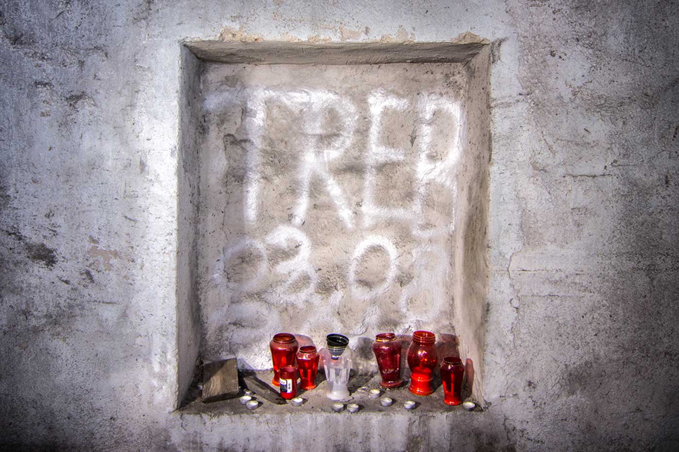 A memorial shrine set into a wall alcove deep within the 'KLEK' complex. Željava Airbase, Croatia.