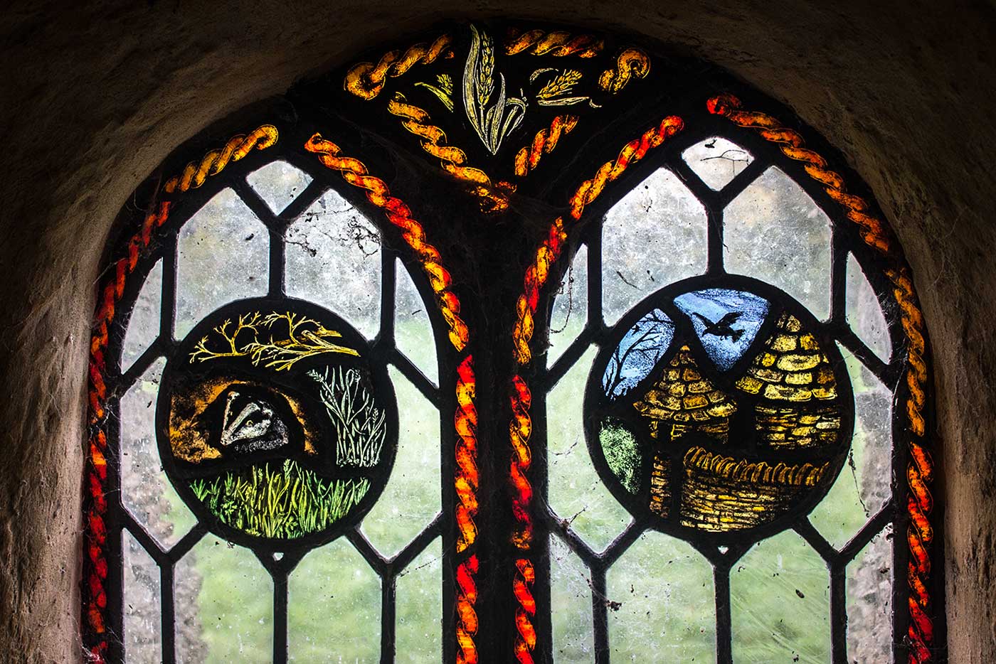 This window in Colin’s Barn features a badger, and a depiction of the barn itself.