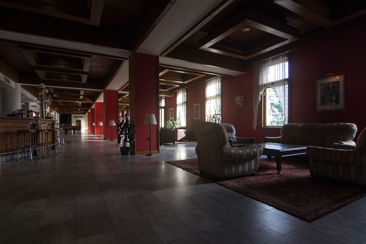 The hotel lobby decorated in dark red, with wood panelling. Interhotel Veliko Turnovo, September 2017.